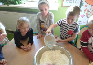Dzieci z grupy 1 podczas mieszania produktów potrzebnych do wykonania chleba.