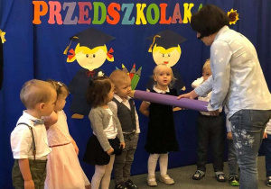 Na zdjęciu widzimy dzieci, które są pasowane kredką przez Panią M. Łyżwę.