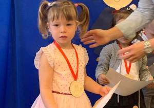 Na zdjęciu widzimy Polę dumną z otrzymania certyfikatu i odznaki przedszkolaka.