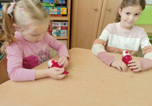 Dzieci z grupy 2 podczas konstruowania małego Mikołaja z szyszki.