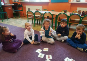 Dzieci łączą w pary kartoniki z tymi samymi kredkami.