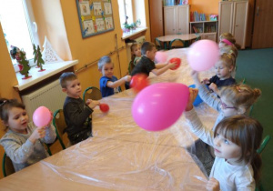 Dzieci z grupy 1 w zabawie z kolorowymi balonami.