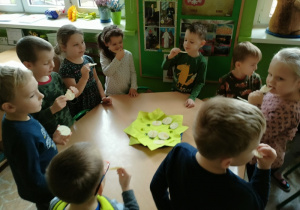 Dzieci z grupy 2 smakują wafelki z miodem.
