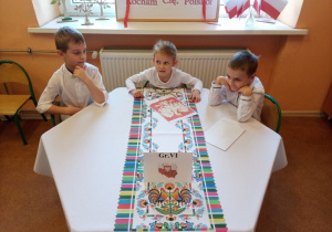 Dzieci z grupy 6 układają puzzle (godło Polski).