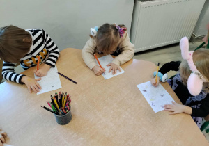Dzieci kolorują przy stoliku.