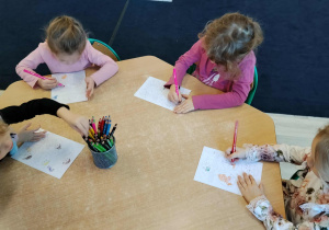 Dzieci kolorują przy stoliku.